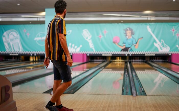 a man standing in front of a bowling alley