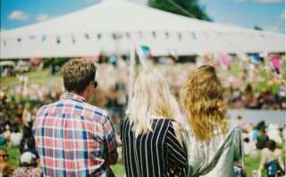 three person's standing front of field